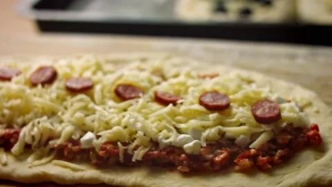 I put the mozarella cheese over the pide. We prepare pide with salami. 4k video Stock Footage 157297817