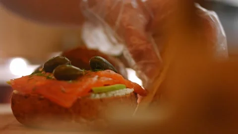 I put the top of the bread on prepare Smoked Salmon Bagel. 4k video Stock Footage 164423107