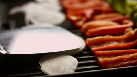 I put the vegetables on the grill. Peppers and white onion 4k cinematography Stock Footage 156449759