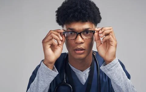 I see the problem...a male nurse wearing glasses while standing against a grey Stock Photos