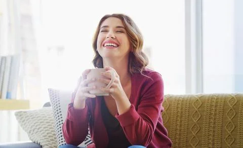 I sure know how to make a cup of java. an attractive young woman sitting on her 스톡 사진