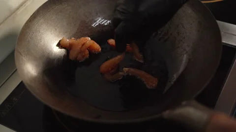 I throw pieces of chicken fillet into a hot pan with vegetable oil. the process Stock Footage 153457410