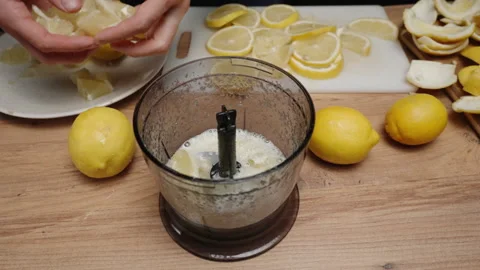 I throw a sliced Lemon into a Blender to grind it for lemonade, slow-motion. Video stock 234201309