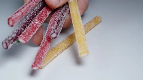 I touch the sugar-coated gummy sticks of different colors, and my hands become c Stock Footage 249624475