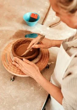 I use clay to create works of art. a woman shaping a clay pot in her workshop. Stock Photos