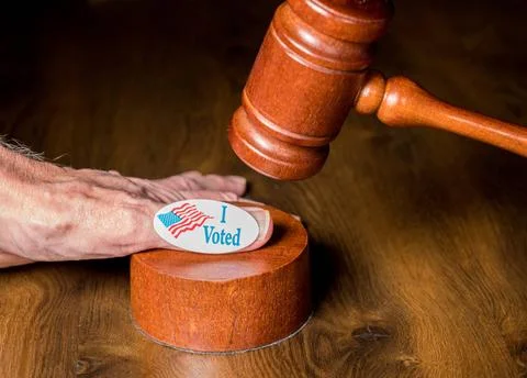 I voted campaign button or sticker on hand with a gavel and mallet to illu... Stock Photos