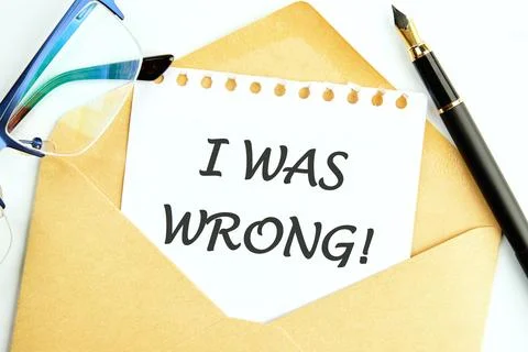 I WAS WRONG text written on a white sheet of notepad sticking out of an envel Foto stock