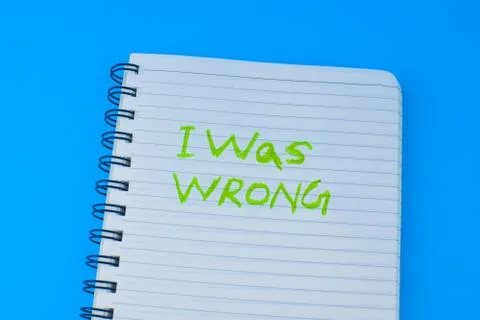 I was wrong written on a white spiraled diary in front of a blue background Stock Photos