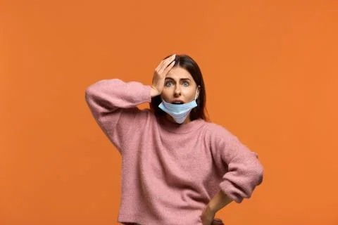 I will get sick. Scared beautiful female putting medical mask it on the chin  Foto stock