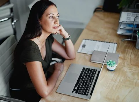 I wonder which task I should do first. an attractive young businesswoman sitting Stock Photos