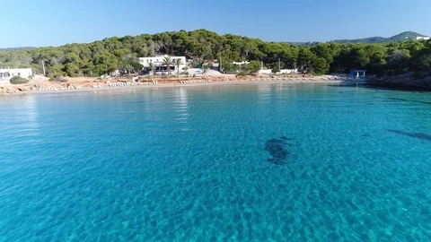 Ibiza Cala Nova over crystal blue water looking towards beach restaurant. Stock Footage 88058752
