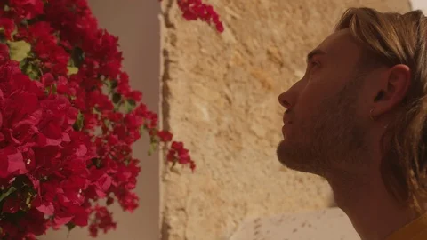 Ibiza Package 93 | man boy closeup looking at red street flowers bougainvillea Stock Footage 118710344