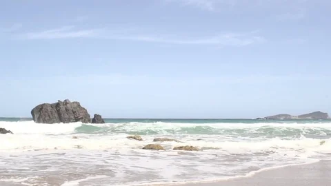 Ibiza, waves on beach with a rock in background Vídeos de archivo 83043611