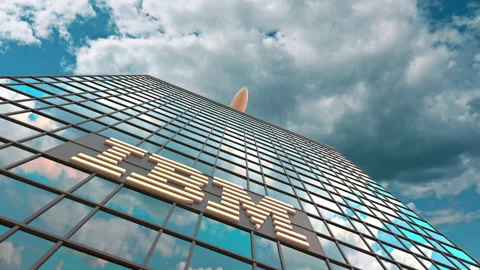 IBM logo on a modern skyscraper reflecting clouds and flying airplane. Editorial Stock Footage 135574019