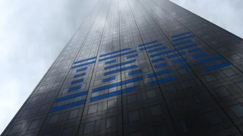 IBM logo on a skyscraper facade reflecting clouds. Editorial 3D rendering Illustrazione stock