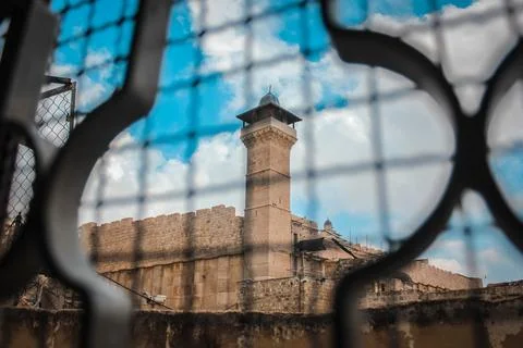 Ibrahimi Mosque minaret viewed through security fence Foto stock