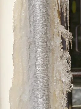 Ice and icicles on a drainpipe. Drainpipe covered with ice and icicles. Stock Photos