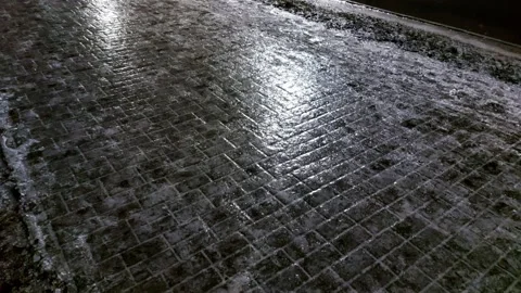 Ice and reflection on the sidewalk at night in winter. Reflection of street Stock Footage 293685015