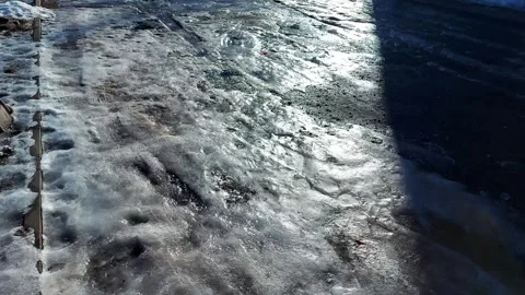 Ice on the asphalt and reflection of light, thaw in winter, background. Stock Footage 295106921