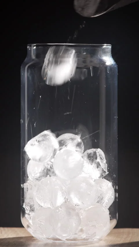 Ice balls falling into glass cup preparing cold summer cocktail for aesthet.. Stock Footage 336661283