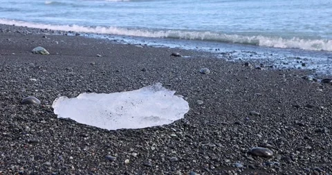 Ice on beach with surf and wave at the Breidamerkursandur glacial plain, by J Stock Footage 213871507