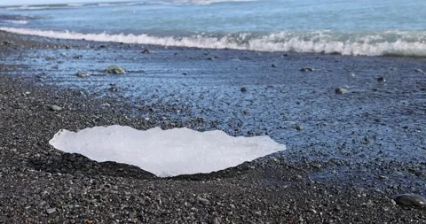 Ice on beach with surf and wave at the Breidamerkursandur glacial plain, by J Stock Footage 213871581