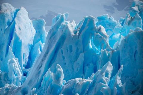 The ice blocks shine against the background of the mountains. Shevelev. Stock Photos