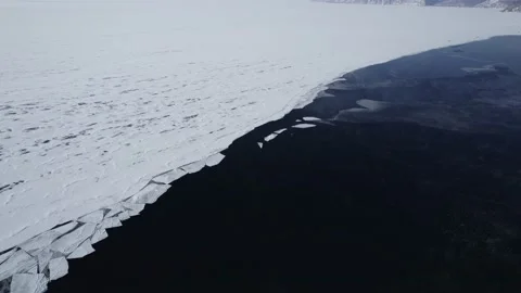 Ice breaks off into the lake, ice and water border Stock Footage 222771662