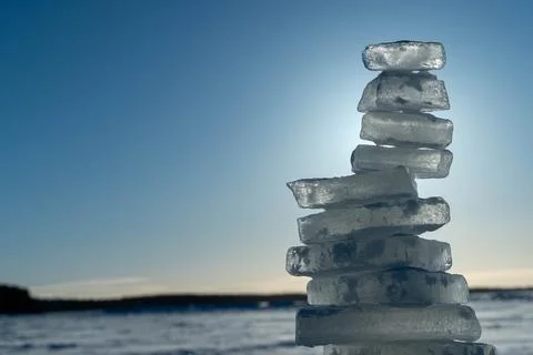 Ice bricks stacked forming a tower on a frozen lake with clear blue sky Foto stock