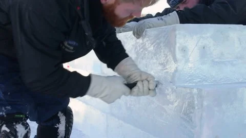 Ice carver cutting block of ice with electric handsaw in competition Stock Footage 147338093