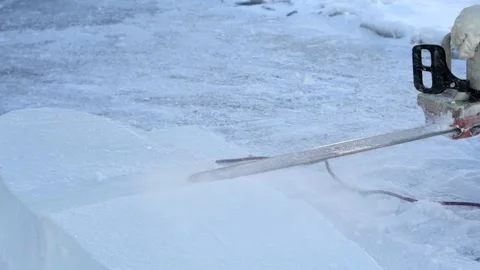 Ice carver cutting block of ice with electric power chainsaw Stock Footage 147347780