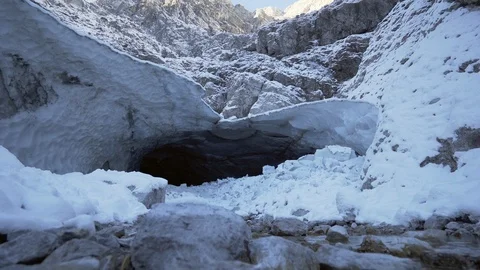 Ice cave in Alps with stream flowing out in winter 스톡 동영상 120986814