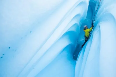 Ice chips fly as climber ascends a narrow canyon on the Matanuska Glacier Stock Photos