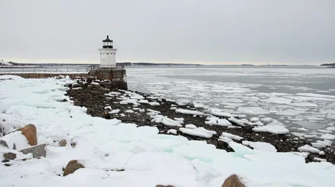 Ice chunks float past Bug Lighthouse, wide shot, South Portland Maine Stock Footage 47086605