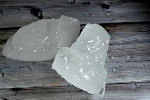Ice chunks of thick solid pieces of frozen water isolated on wooden backgro.. Stock Photos