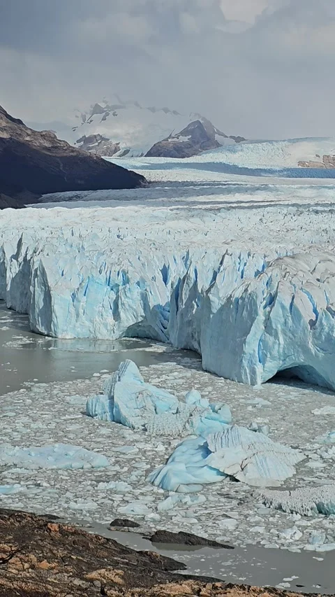 Ice Cliff And Floating Blocks Beside Gray Water, Argentina – Vertical 8K Video stock 306469525