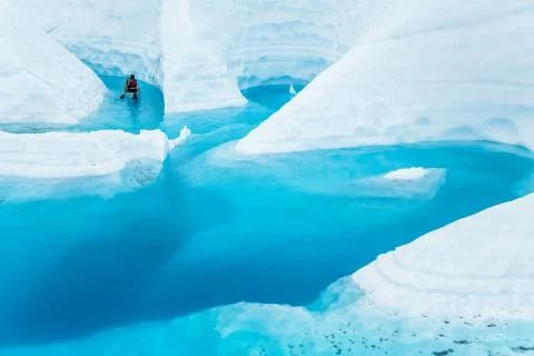 Ice climber boating through winding canyons flooded by glacier water of the M Stock Photos