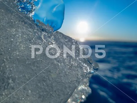 Ice is close. Sun glare on blue ice close up. Stock Photos