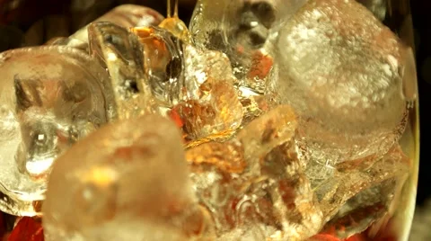 Ice in cocktail glass, adding Whiskey, closeup Stock Footage 65366816