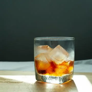 Ice cold brew coffee drink in glass on wood with dark blue wall background Stock Photos