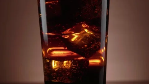 Ice cold Cola with ice cubes in soda - slow motion shot Stock Footage