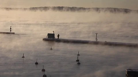 Ice-cold steaming sea, ice fisherman on the pier Video stock 58814235