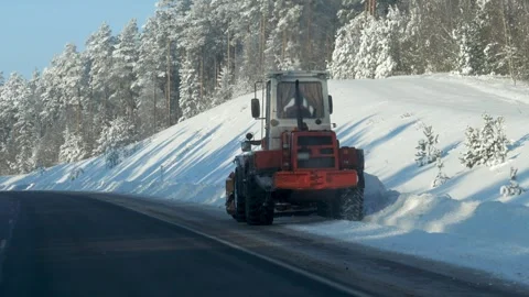 Ice covered highway being cleared by snowplow in sunny winter scene Stock Footage 327143033