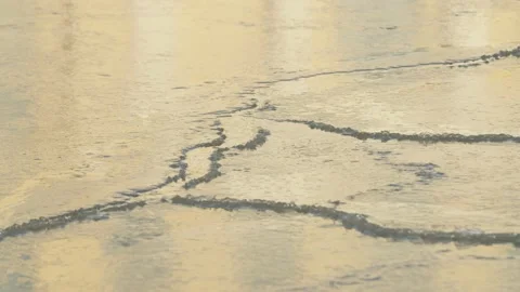 Ice cracking on the surface of water with warm light reflecting  Stock Footage 146265480