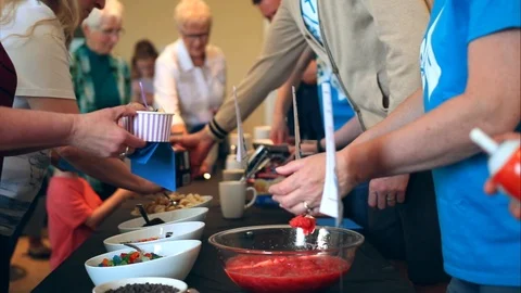 Ice cream bar of a function. Toppings and cream being put on ice cream in a 스톡 동영상 91463256