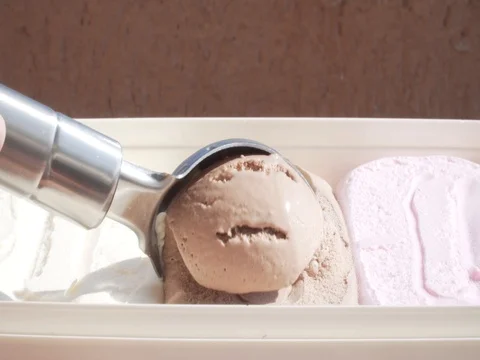 Ice cream being scooped out of container by a metal spoon Stock Footage 80425161