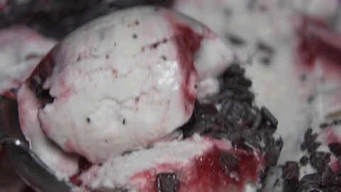 Ice-cream with cherry jam and chocolate pieces being scooped. Close up Stock Footage 91508800