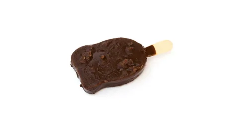 Ice cream with chocolate outer melting on a white background time-lapse 4K Stock Footage 65377326
