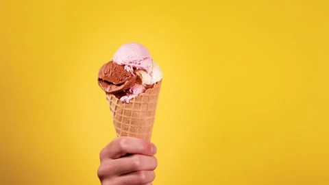 Ice Cream Cone With Multiple Flavors Held by a Hand Stock Footage 270044436