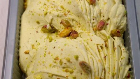 Ice cream in a container.Appetizing ice cream with whole nuts. Freshly frozen Stock Footage 274836848